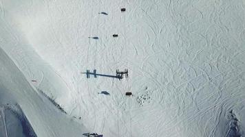 vue aérienne par drone des télésièges et des montagnes enneigées en hiver.