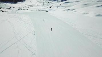Aerial drone view of a skier skiing on top of a snow covered mountains in the winter. video
