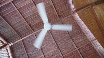Refrigeración por ventilador de techo en un complejo hotelero con techo de paja en una isla tropical.