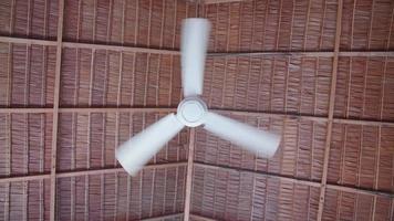 Refrigeración por ventilador de techo en un complejo hotelero con techo de paja en una isla tropical.