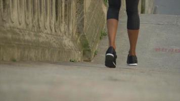Closeup of legs on a woman running on stairs in a city for a workout.