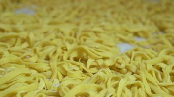 pasta recién hecha esparcida sobre la mesa de la cocina antes de cocinarla. productos semi-terminados video