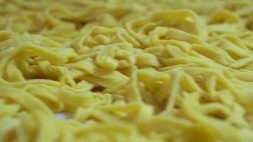 freshly made pasta spread out on the kitchen table before cooking . semi-finished products video