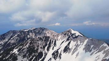 voando sobre os picos das montanhas nevadas com nuvens video