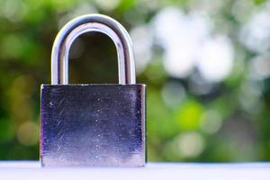 Padlock on green bokeh background and business security concept, protecting data personal information photo