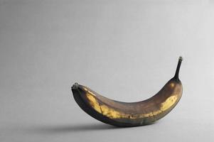 A rotten banana on grey background with empty copy space for text photo