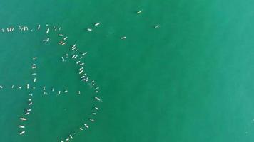foto aérea de surfistas remando para protestar no oceano. video