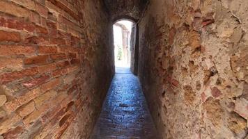 luz al final del túnel, punto de vista de caminar por un camino estrecho en el pueblo de pienza, toscana, italia, europa.