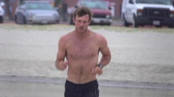 un hombre que hace jogging en la bahía y la playa. video