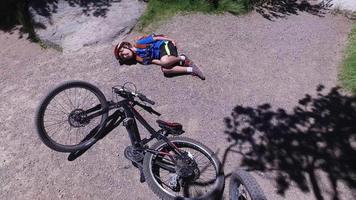 un niño monta su bicicleta de montaña y se estrella, llorando de dolor en el suelo. video