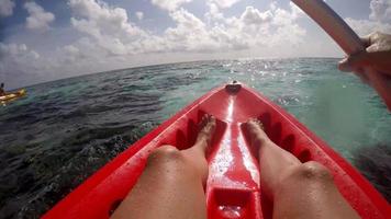 pov vista de una pareja de hombre y mujer en kayak alrededor de una isla tropical.