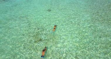 Aerial drone view of a man and woman couple snorkeling with seascooters. video