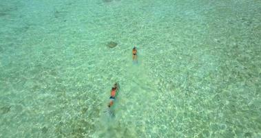 Aerial drone view of a man and woman couple snorkeling with seascooters. video