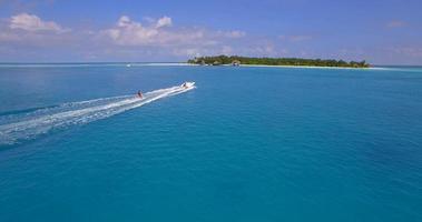 vista aérea de drone de un hombre de esquí acuático cerca de una isla tropical. video