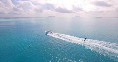 vista aérea do drone de um homem esqui aquático perto de uma ilha tropical.