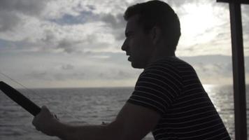 silhueta de um homem pescando de um barco. video