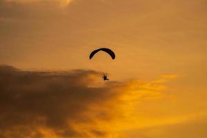 The silhouette of the paramotor at sunset photo