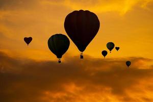 The silhouette of Balloons on sky at sunset photo