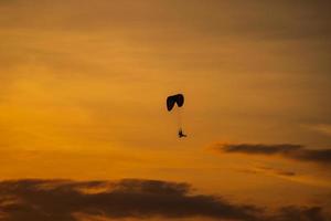 la silueta del paramotor al atardecer foto