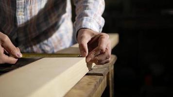 Man Measures a Wooden Board