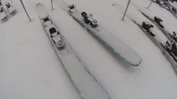 esquis e pranchas de snowboard cobertas de neve em uma estação de esqui.