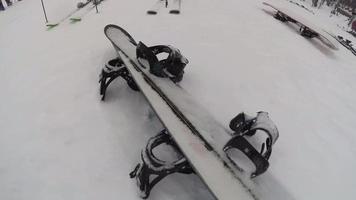 esquis e pranchas de snowboard cobertas de neve em uma estação de esqui.