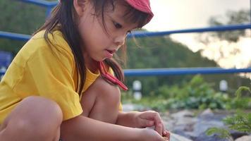 heureuse petite fille jouant avec des feuilles dans le parc d'été. enfance heureuse. video