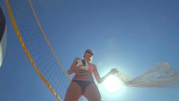 POV of a woman beach volleyball player putting the balls in a bag.