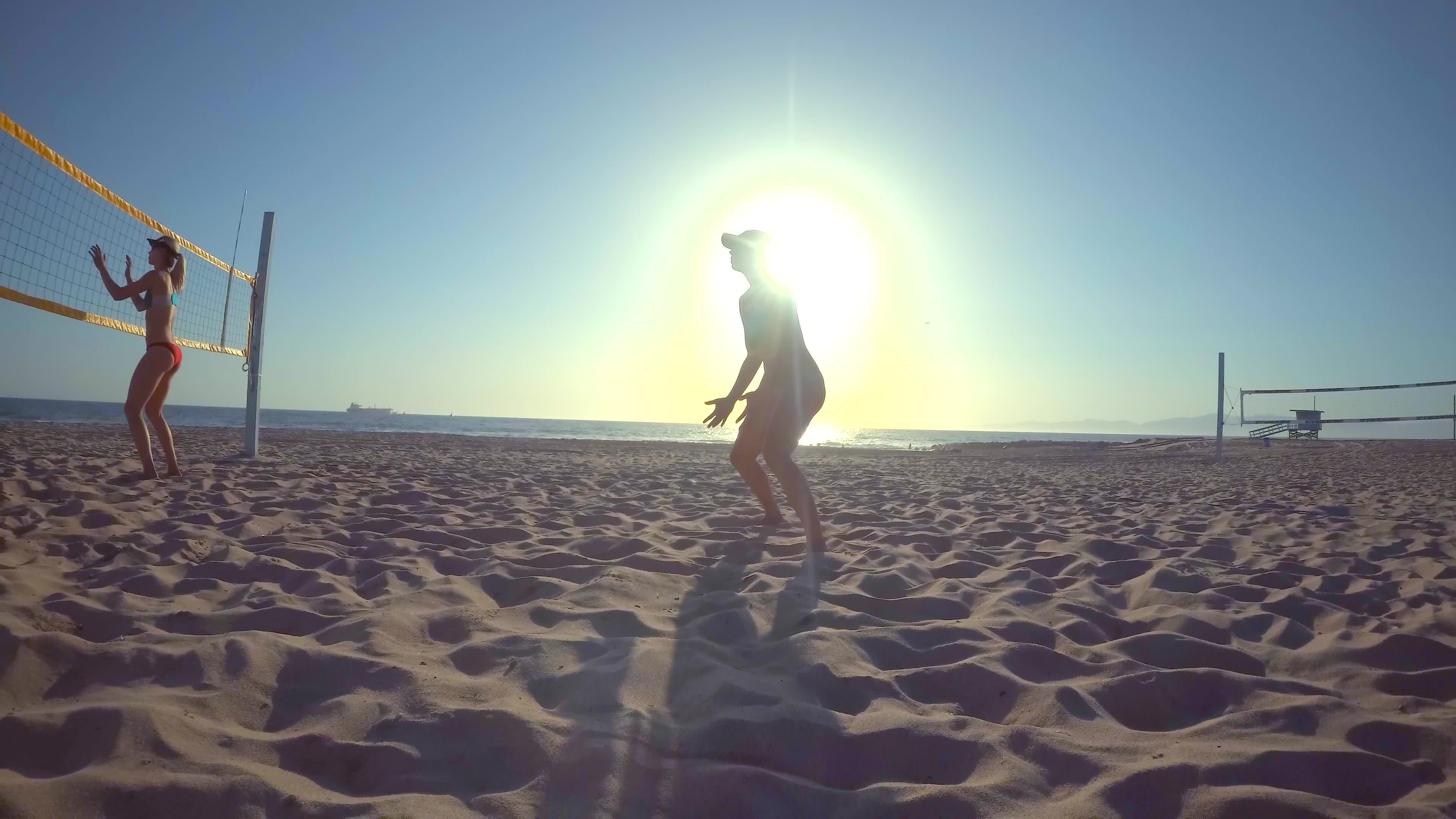 POV of women players playing beach volleyball with a girl diving to dig