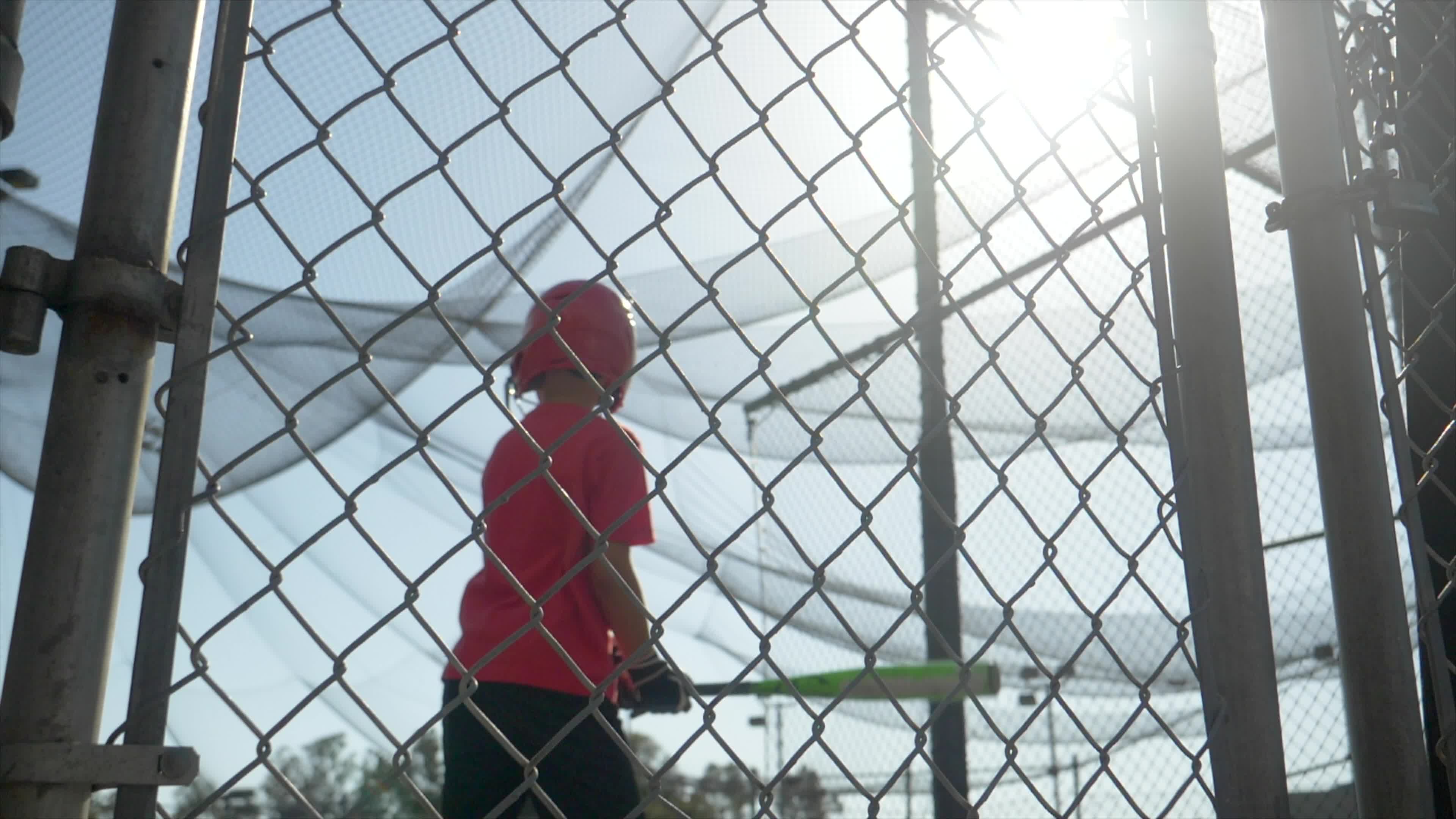 A boy swings the bat and practices little league baseball at the