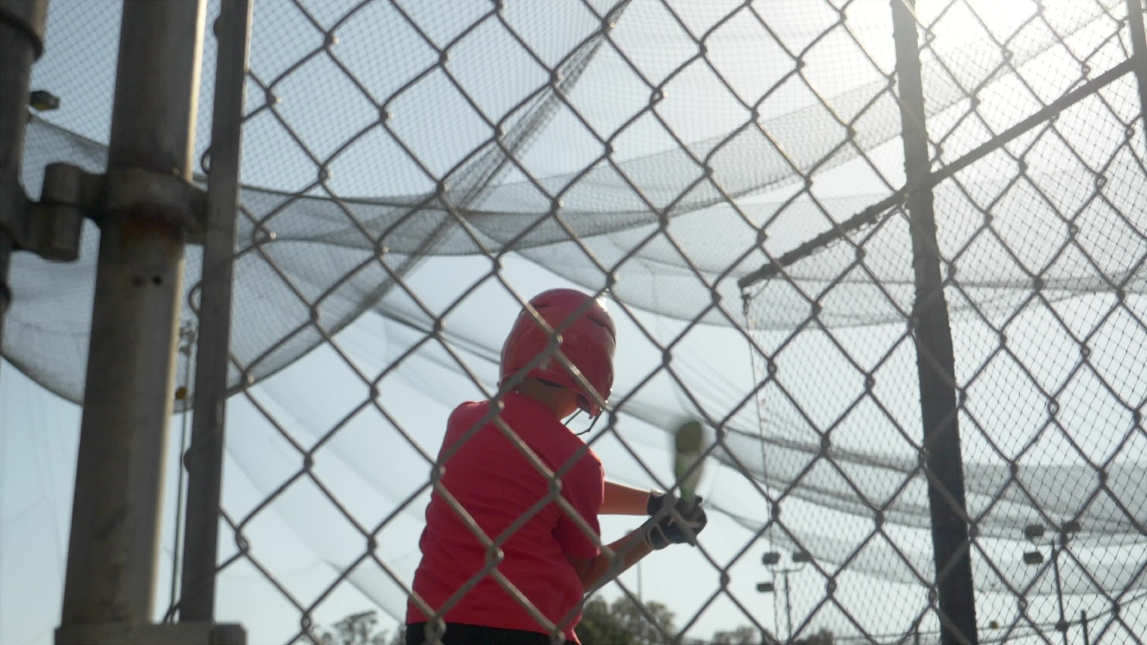 A boy swings the bat and practices little league baseball at the