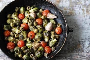 Brussels sprouts with vegetables and herbs in a pan photo