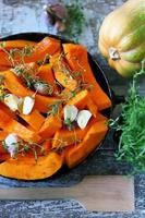 Pieces of pumpkin in a skillet before baking photo