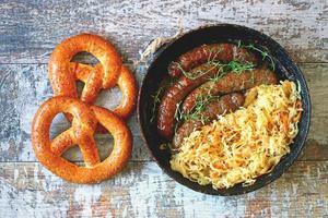 Salchichas bávaras en una sartén con chucrut guisado comida oktoberfest foto