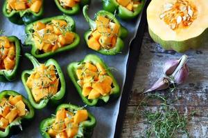 Green peppers stuffed with pumpkin pieces photo