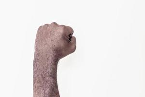 mano masculina apretada en un puño sobre un fondo blanco. un símbolo de la lucha por los derechos de los negros en américa. protesta contra el racismo. foto