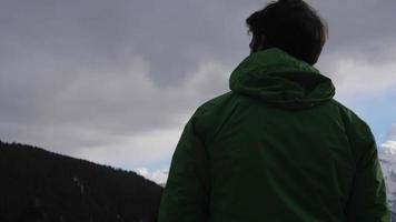 silhueta de um homem de pé e olhando a vista panorâmica de nuvens e montanhas no inverno. video