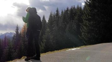 um casal olhando para a vista de nuvens e montanhas no inverno. video