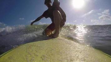 pov van een surfer die golven op zijn surfplank surft.