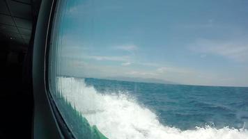 Ver por la ventana de un barco a motor navegando en el mar azul.