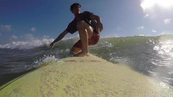 POV of a surfer surfing waves on his longboard surfboard.