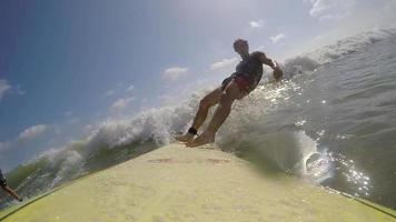 POV of a surfer surfing waves on his longboard surfboard.
