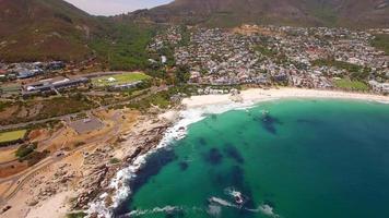 vista aérea de drone de viaje de la playa de camps bay, ciudad del cabo, sudáfrica. video