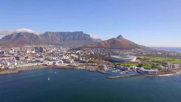 vista aérea de drone de viaje de ciudad del cabo, sudáfrica, con la montaña de la mesa y el estadio. video