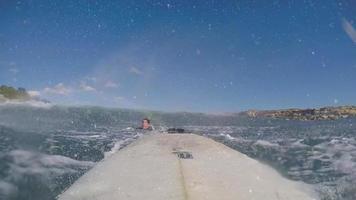 POV of a surfer surfing waves on his surfboard in a full wetsuit. video