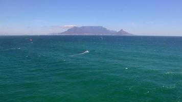 Luftreisedrohnenansicht des Tafelbergs und der Tafelbucht und Kiteboarder von Bloubergstrand, Kapstadt, Südafrika. video