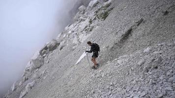 alpinista descendo a montanha na encosta rochosa. video