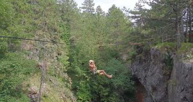 un hombre intenta mantener el equilibrio y cae mientras se afloja en una cuerda floja. video