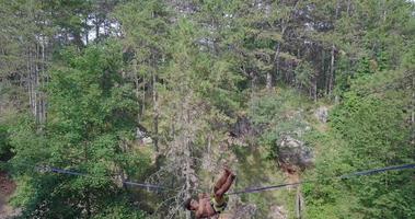 un hombre cae mientras se balancea en una cuerda floja en las montañas. video
