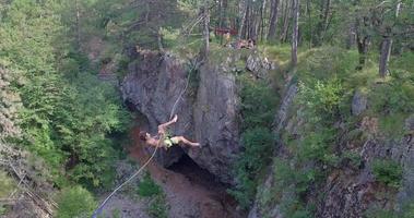 un hombre cae mientras se balancea en una cuerda floja en las montañas. video